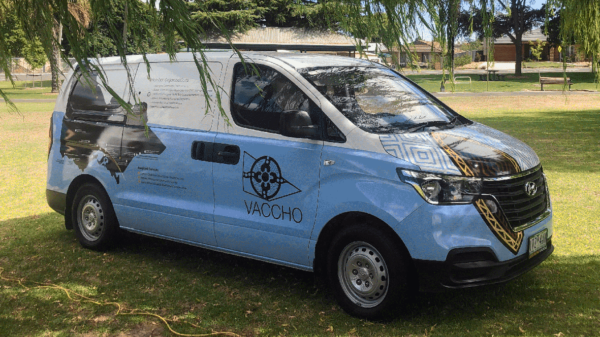 Side profile of the VACCHO Covid 19 Vaccine Van parked on grass